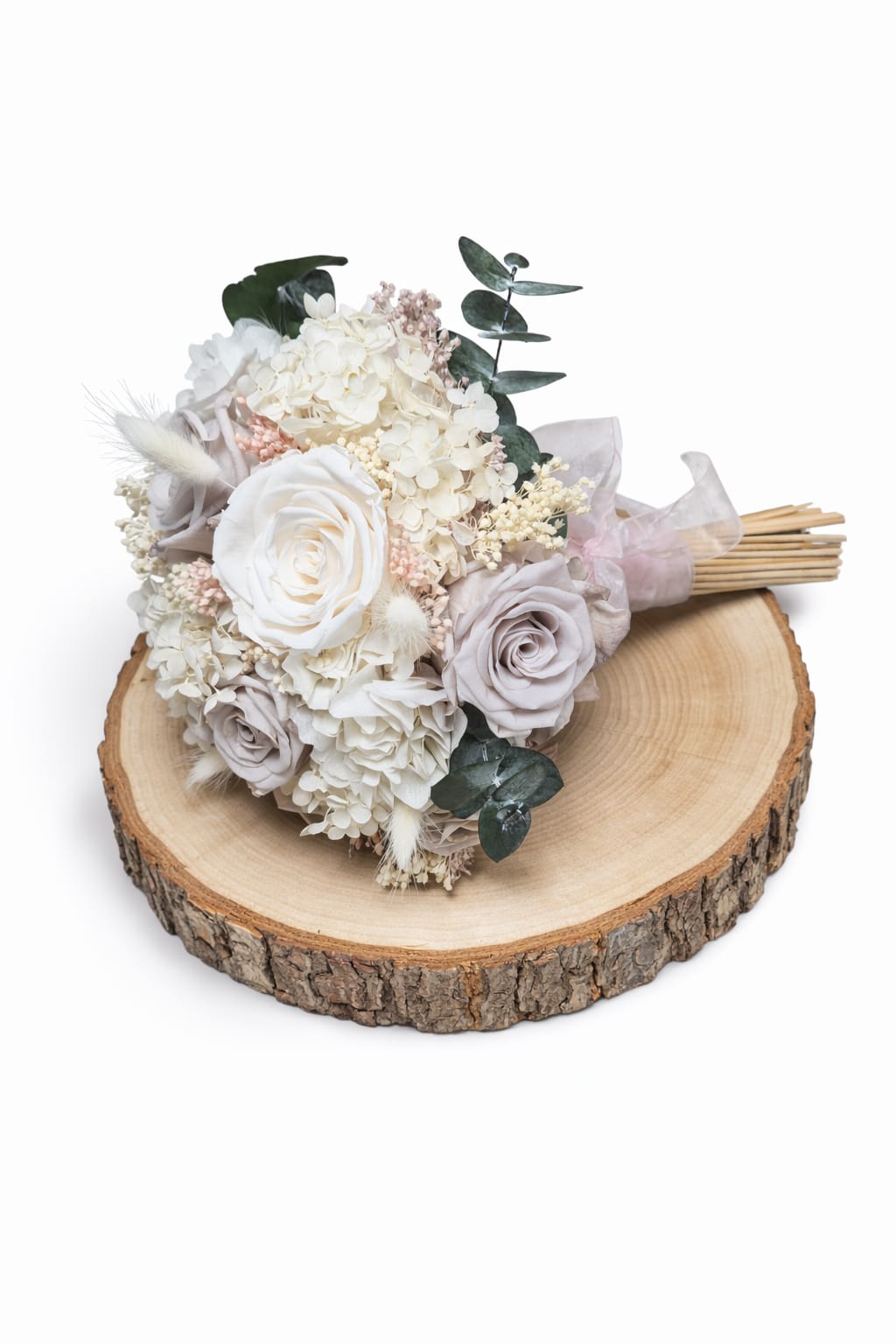 Ramo de novia artesanal con flores preservadas y lazo suave en colores neutros.